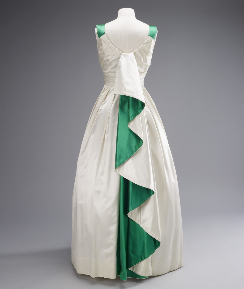 An evening dress in heavy cream satin, which incorporates Pakistan’s national colours through a dramatic emerald-green pleat cascading down the back.