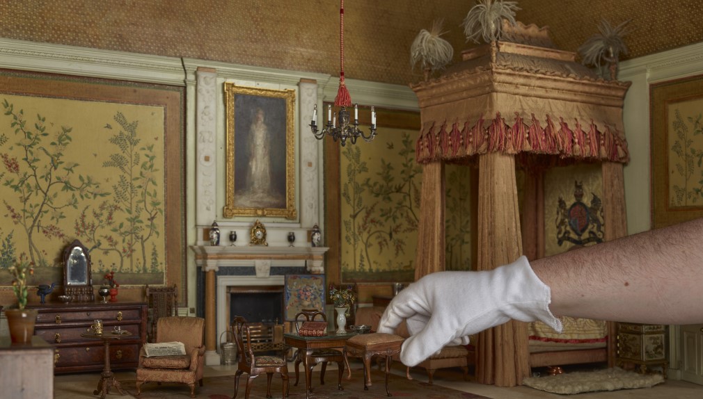 The King's Bedroom in Queen Mary's Dolls' House The King's Bedroom in Queen Mary's Dolls' House with a hand reaching in to pick up furniture