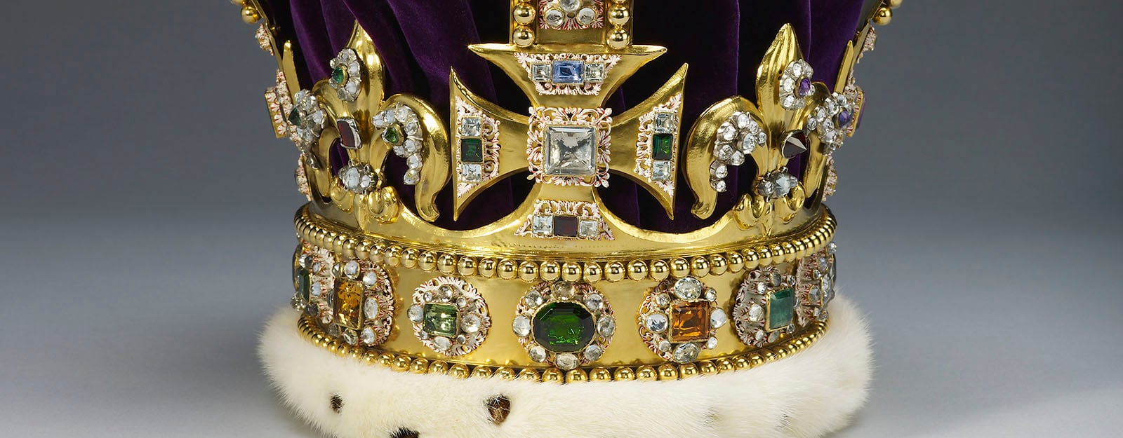 A close up of a gold crown set with jewels