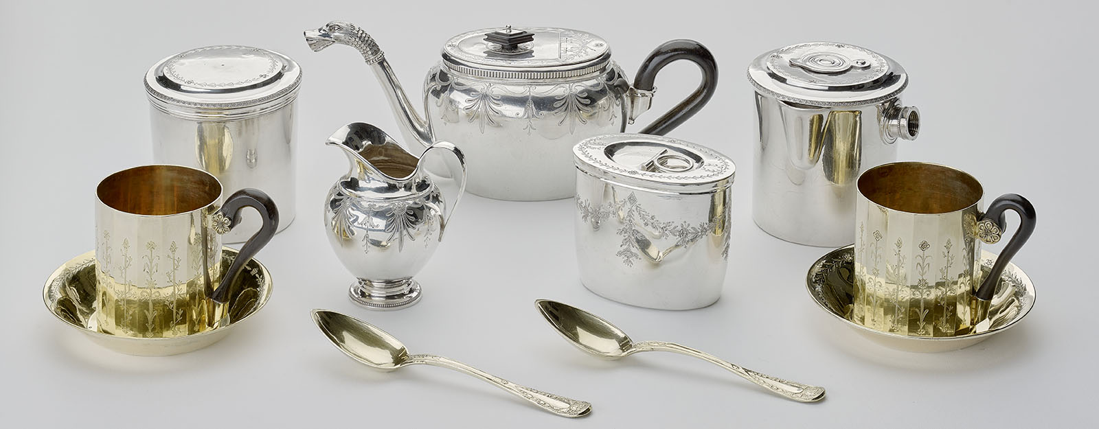 A selection of silver cups, tea pot and spoons.