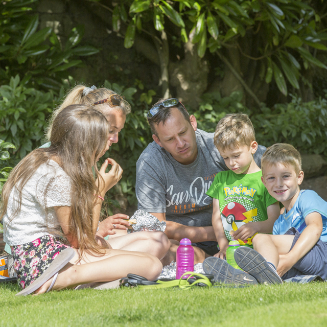 Family enjoying a picnic in the garden at Buckingham Palace