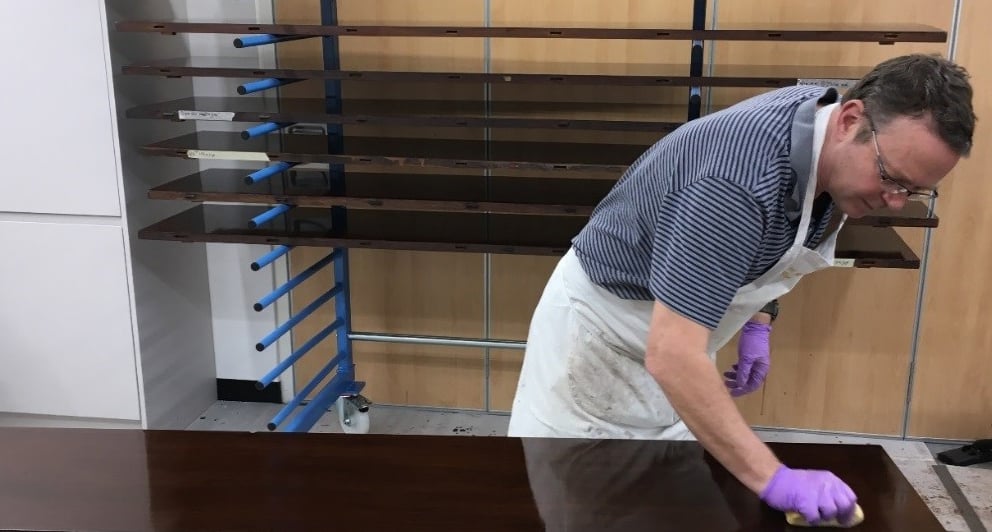 conservator polishing the table