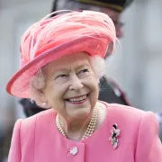 Queen Elizabeth II wearing pink and smiling