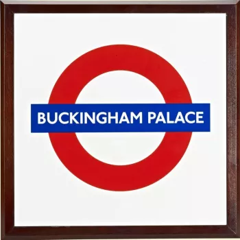 A square enamel plaque with the London Underground logo and inscribed BUCKINGHAM PALACE. Framed in wood.

The first use of a roundel design was at St. James's Park underground station in 1908. The font has since been slightly modernised but the basic fo