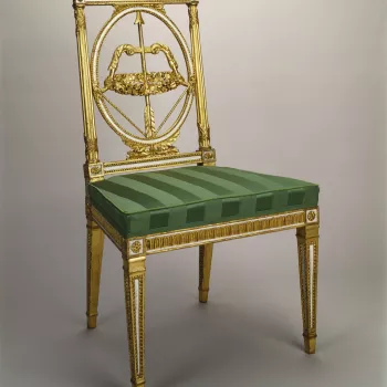 A giltwood and white painted side chair, the rectangular back with an oval-framed bow and arrow splat carved with a wreath of flowers; rectangular uprights bound with carved ribbon. Some areas painted white.&nbsp;Square reeded legs. Upholstered in green s