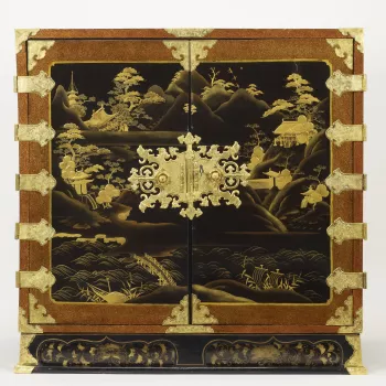 The design of this cabinet represents a type of Japanese export lacquer popular for its decoration of landscapes with mountains and temples overlooking water. Its shape is adapted from earlier export cabinets with a fall-front concealing drawers of variou