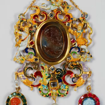 Obverse: a sard cameo representing a bearded male head, in profile to the right; with surrounding open scrollwork frame set with seven table-cut diamonds and two rubies and incorporating: to the left, a reclining figure of Cupid; to the right, Apollo with