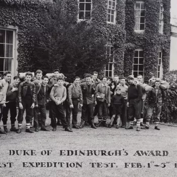 Photograph of a group of young boys with rucksacks and outdoor clothing pictured standing outside an ivy clad building who took part in the Duke of Edinburgh's Award First Expedition