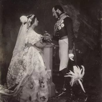 Photograph showing a full length portrait of Queen Victoria (1819-1901) and Prince Albert (1819-61), photographed at Buckingham Palace. Queen Victoria stands in right side profile and wears formal court dress. Prince Albert stands in left side profile, ho