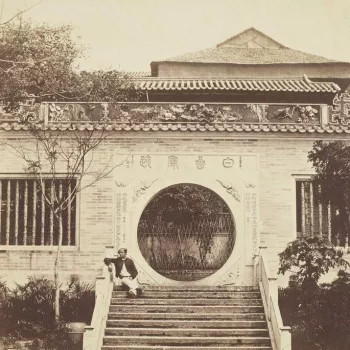 A man sits on the steps leading up to a pavilion