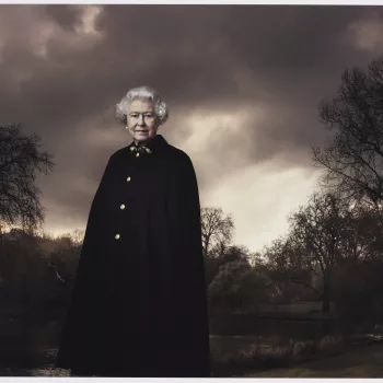 Photograph of&nbsp;HM&nbsp;Queen Elizabeth II standing in three-quarters length and&nbsp;facing the viewer. The Queen is set against a background featuring trees and clouds and she is pictured wearing&nbsp;the Admiral's Cloak.
In this portrait Leibovitz 