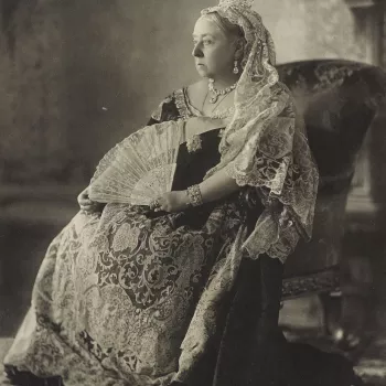 Photograph of Queen Victoria, full length, seated and facing three-quarters right, dressed in lace. She holds a fan in her left hand. 

This photograph of the Queen, which was used as an official Jubilee portrait, was actually taken in July 1893, on the