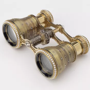 A pair of engine-turned gold opera glasses, scattered with diamonds and ringed with pearls at both the looking and viewing ends of each glass, the central hinge with a diamond-set octagonal twister and pearl finial. Tiffany &amp; Co. were well known for t