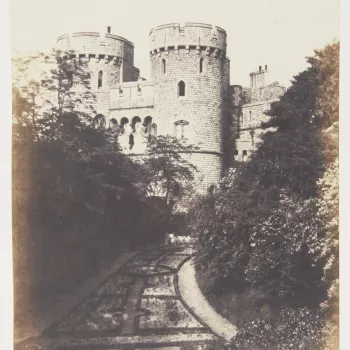 Photograph of the Norman Tower, taken from the Moat Garden, Windsor Castle. There are trees on either side of the garden.