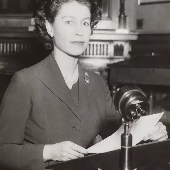 Photograph of HM Queen Elizabeth II (b.1926) seated at a microphone and holding a script during her first radio Christmas Broadcast from Sandringham.
For her first Christmas broadcast in 1952, The Queen sat at the same desk and chair that her grandfather 