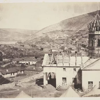 Photograph of Balaklava taken from the Russian Church, showing the upper harbour and the Church of Kadikoi in the distance. The Russian Church is in the foreground to the right. The timber dome and roof are exposed and the doors and windows are filled wit