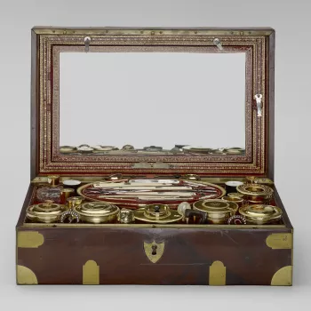 A mahogany&nbsp;and brass-mounted box, lined with tooled red leather&nbsp;and containing a French silver-gilt, ivory, mother of pearl and cut-glass travelling&nbsp;service, the pieces packed into fitted&nbsp;leather trays. Many pieces are&nbsp;engraved wi