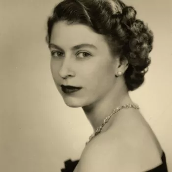 Head and shoulders portrait of HM Queen Elizabeth II, facing the viewer, her torso in left side profile. She wears a black taffeta evening dress with&nbsp;the&nbsp;South Africa Necklace that was a 21st birthday gift from the Government of the Union of Sou