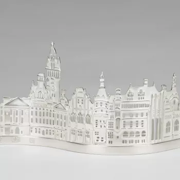 This tealight holder shows a condensed silhouette of the historic buildings in the city of Sheffield, for centuries a centre for metalwork including cutlery and silver. A tealight placed in the holder at the back would shine its light through the spaces c