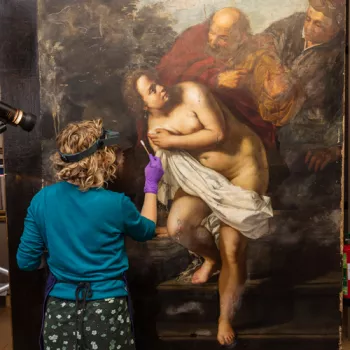 A conservator works on Susanna and the Elders