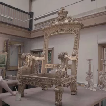 conservator standing with throne in the workshop