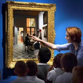 A group of children look closely at a painting by Vermeer with their teacher