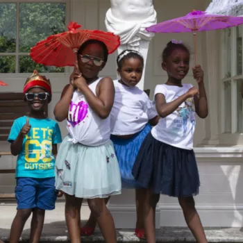 Group of 4 children with parasols in Buckingham Palace gardens