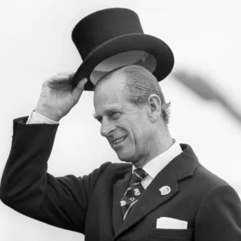 Prince Philip raises his top hat to acknowledge a crowd