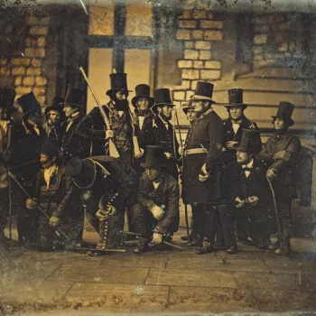 Photograph showing assorted members of the Royal Household keepers and beaters standing around in their uniforms