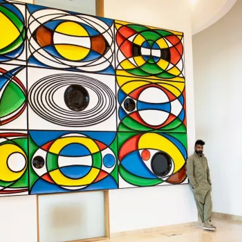 Artist Graeme Evelyn standing in front of his own abstract piece of artwork