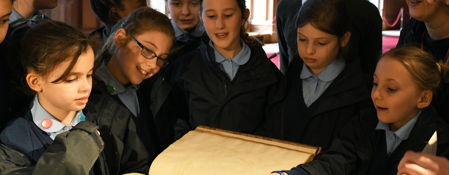 School children looking at a book